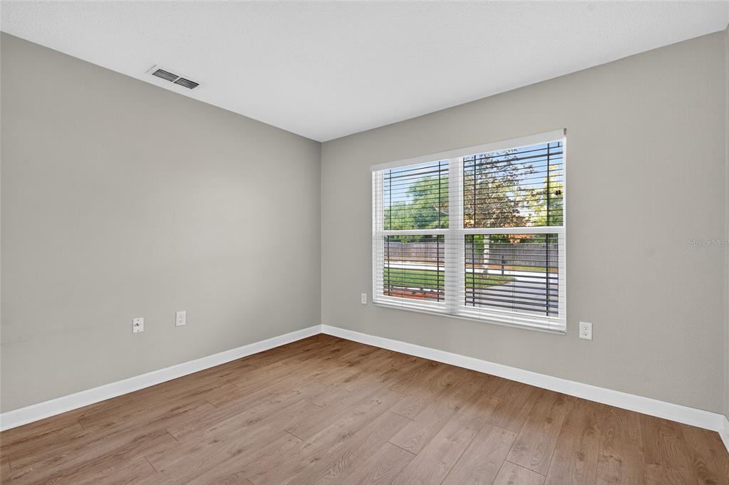 302 Leafwood Road Tarpon Springs, FL 34689 - Photo 38 of 55 an empty room with wooden floor and windows