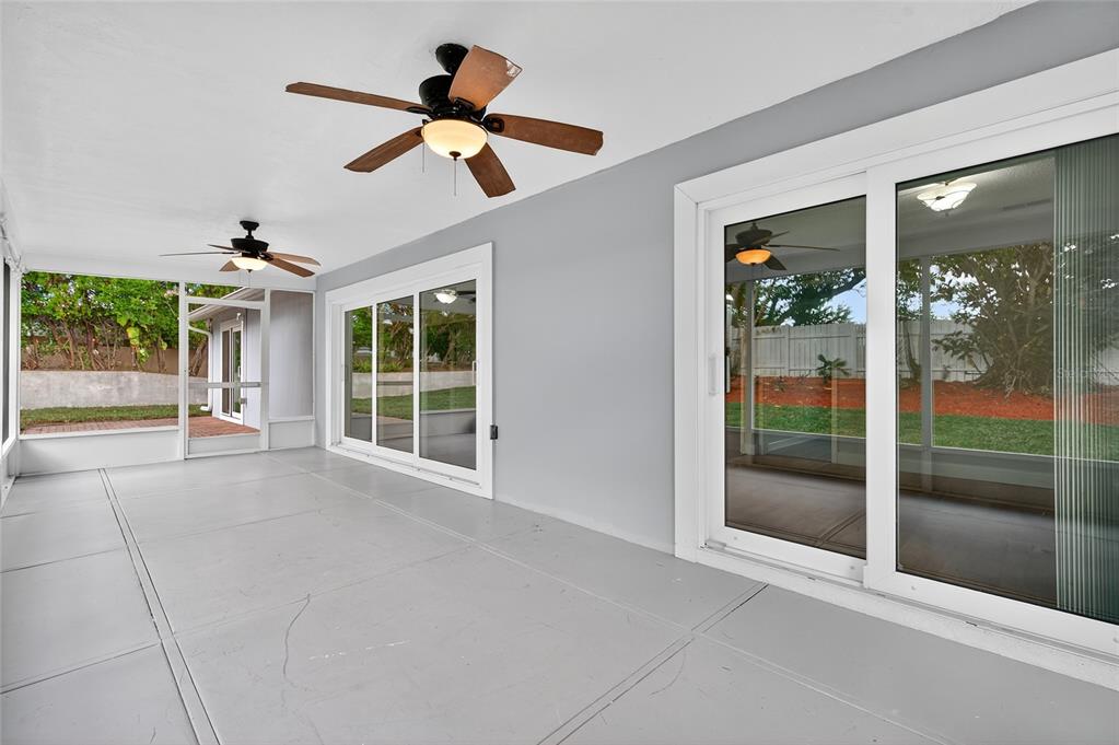 302 Leafwood Road Tarpon Springs, FL 34689 - Photo 42 of 55 a view of an empty room with a floor to ceiling window and a ceiling fan