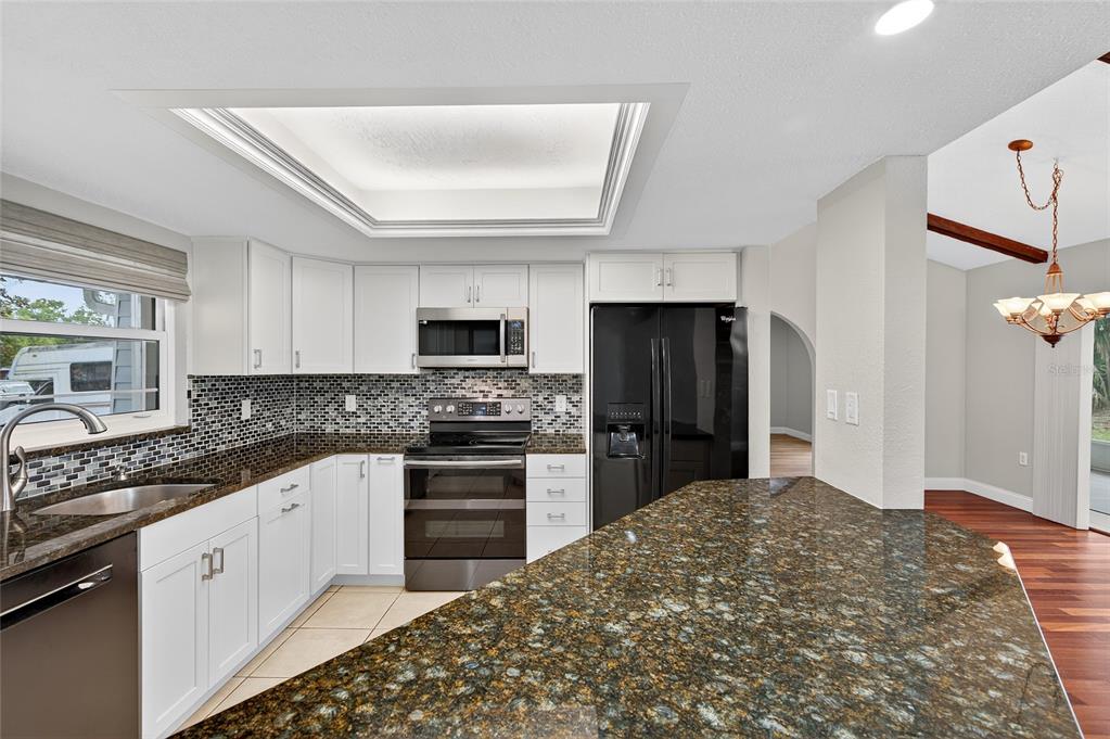 302 Leafwood Road Tarpon Springs, FL 34689 - Photo 8 of 55 a kitchen with stainless steel appliances granite countertop a refrigerator sink and stove