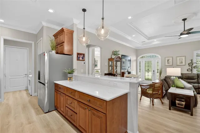a large white kitchen with lots of counter space dining table and stainless steel appliances