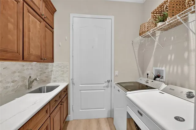 a view of a brick house with a big yard plants and large trees