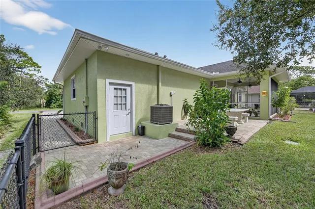 a view of a house with brick walls and a yard with plants