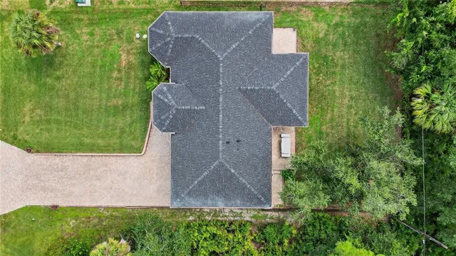 an aerial view of a houses with a yard and lake view