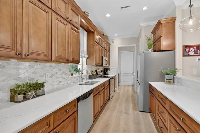 a kitchen with stainless steel appliances a stove a microwave a sink and cabinets