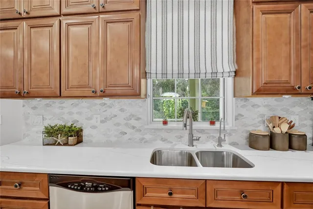 a large kitchen with stainless steel appliances a large center island attached withe living room