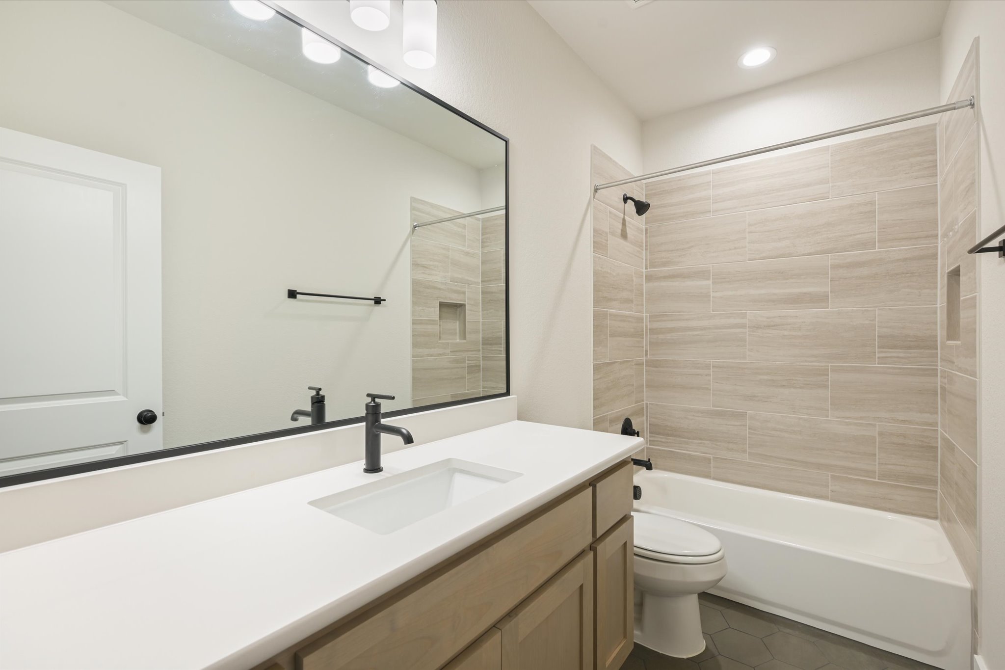 913 Presa Arriba Road Austin, TX 78733 - Photo 21 of 30 A well-appointed bathroom with a spacious vanity, sleek fixtures, and a tub-shower combination.