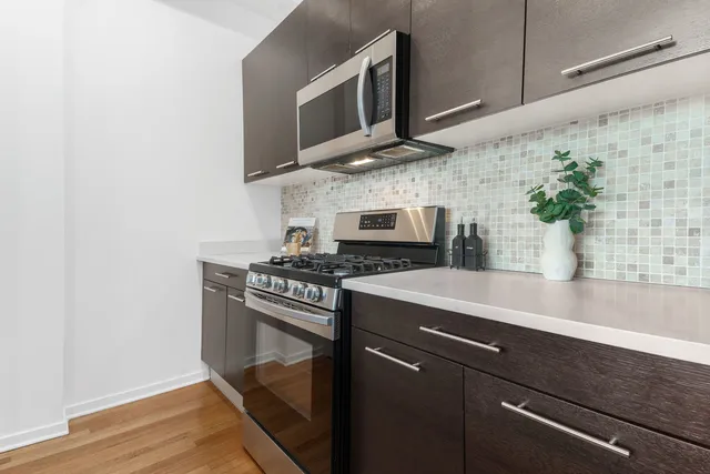 a kitchen with stainless steel appliances a sink a stove and microwave
