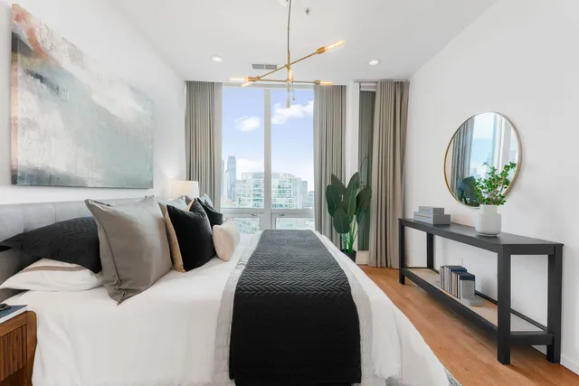 a bedroom with bed and a large window