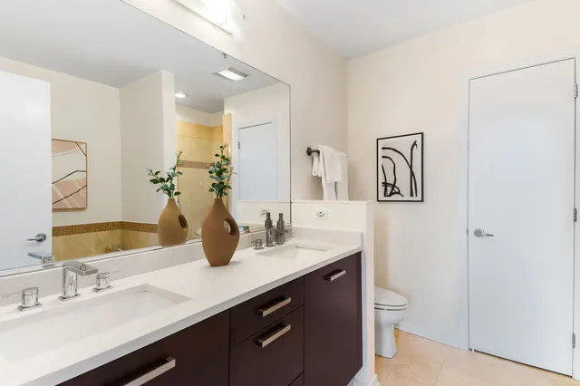 a bathroom with a granite countertop sink a toilet and mirror