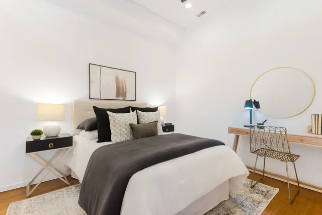 a bedroom with a bed a mirror and chair