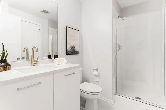 a bathroom with a sink a toilet and shower