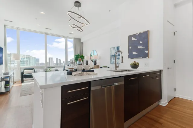 a kitchen with kitchen island granite countertop a sink cabinets and wooden floor