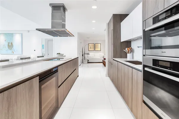 a large kitchen with stainless steel appliances lots of counter space and a sink