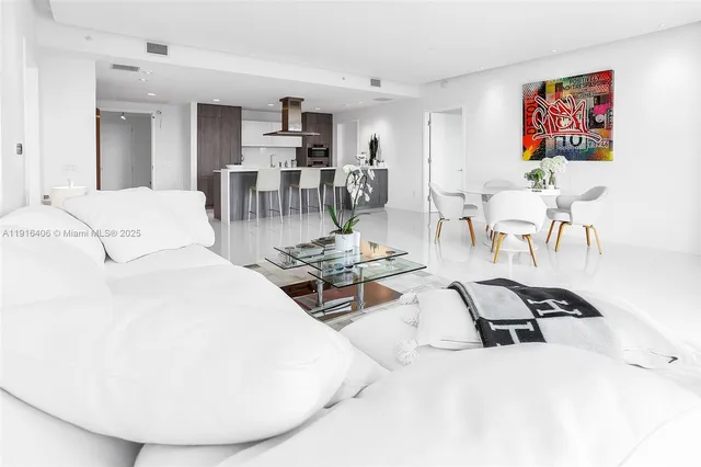 a living room with furniture a table and kitchen view