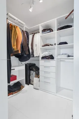 a view of walk in closet with clothes and shoes