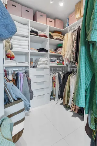 a view of walk in closet with clothes and shoes