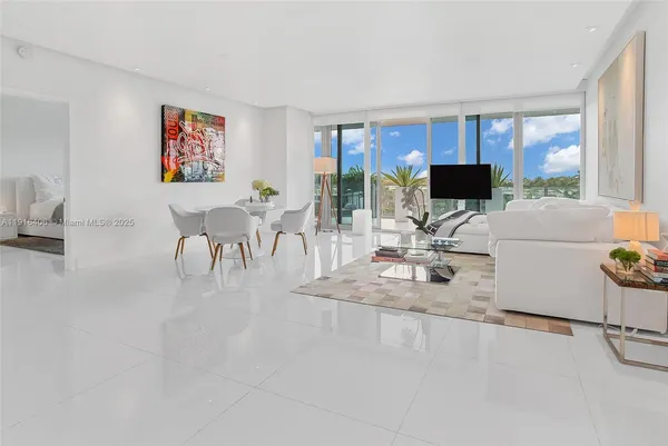 a living room with furniture a flat screen tv and a large window