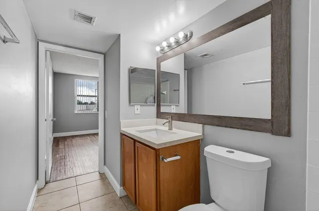 a bathroom with a sink a toilet and mirror