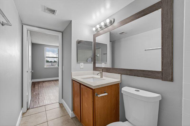 744 Executive Center Drive, Unit 11 West Palm Beach, FL 33401 - Photo 13 of 29 a bathroom with a sink a toilet and mirror