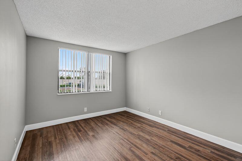 744 Executive Center Drive, Unit 11 West Palm Beach, FL 33401 - Photo 14 of 29 wooden floor in an empty room with a window