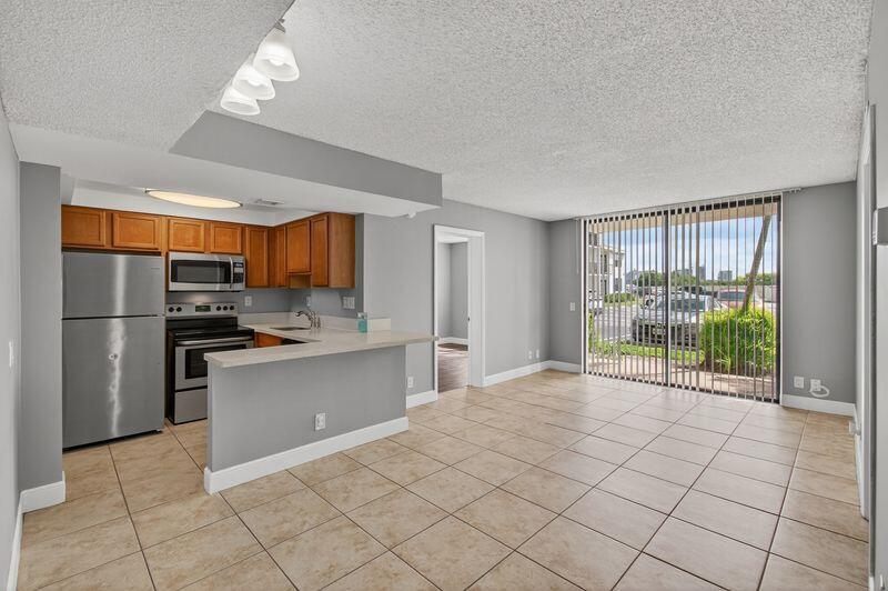 744 Executive Center Drive, Unit 11 West Palm Beach, FL 33401 - Photo 6 of 29 a open kitchen with stainless steel appliances granite countertop a refrigerator and a sink