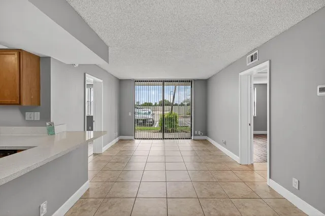 a view of an empty room with window and bathroom