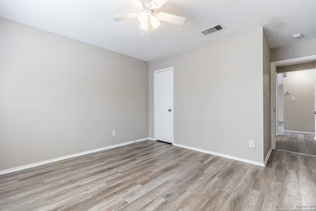 a view of an empty room with wooden floor
