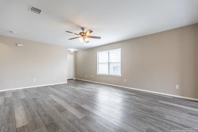 wooden floor in an empty room with a window