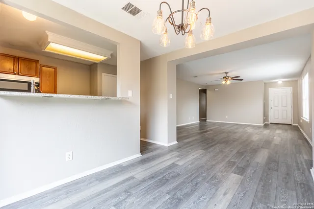 a view of a room with wooden floor and ceiling fan
