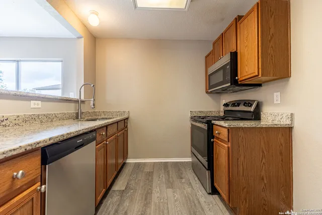 a kitchen with stainless steel appliances granite countertop a sink stove and microwave