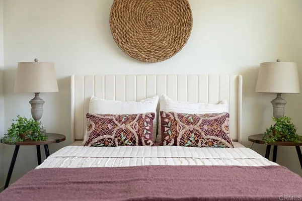 a view of a bedroom with a bed and a potted plant
