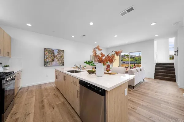 a kitchen with a sink and wooden floor