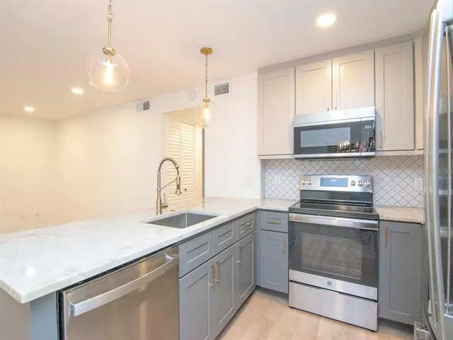 a kitchen with sink a stove and cabinets