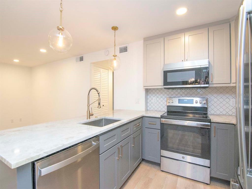 107 South Obrien Street, Unit 118 Tampa, FL 33609 - Photo 11 of 30 a kitchen with sink a stove and cabinets