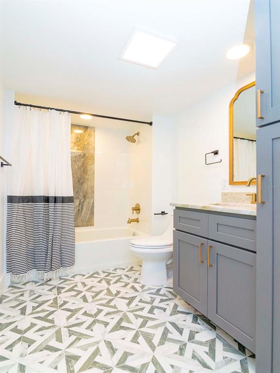 107 South Obrien Street, Unit 118 Tampa, FL 33609 - Photo 17 of 30 a bathroom with a granite countertop sink toilet a shower and a bathtub