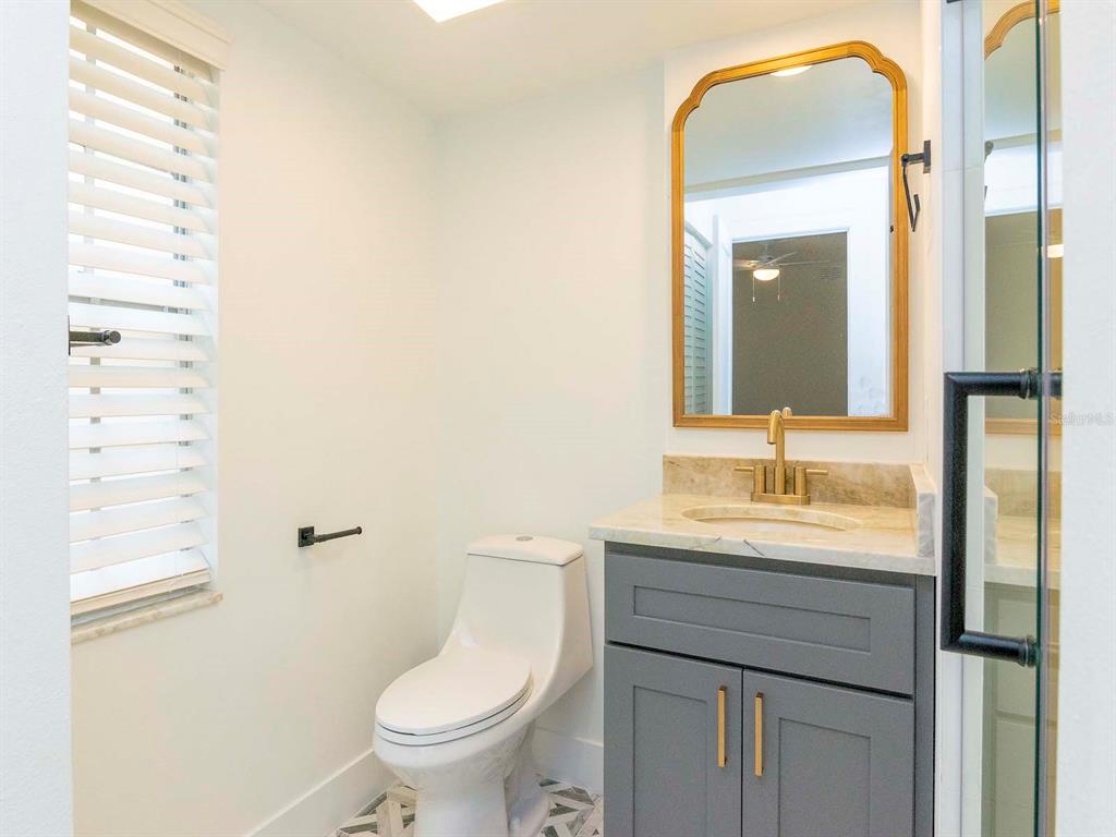 107 South Obrien Street, Unit 118 Tampa, FL 33609 - Photo 21 of 30 a bathroom with a toilet a sink and mirror