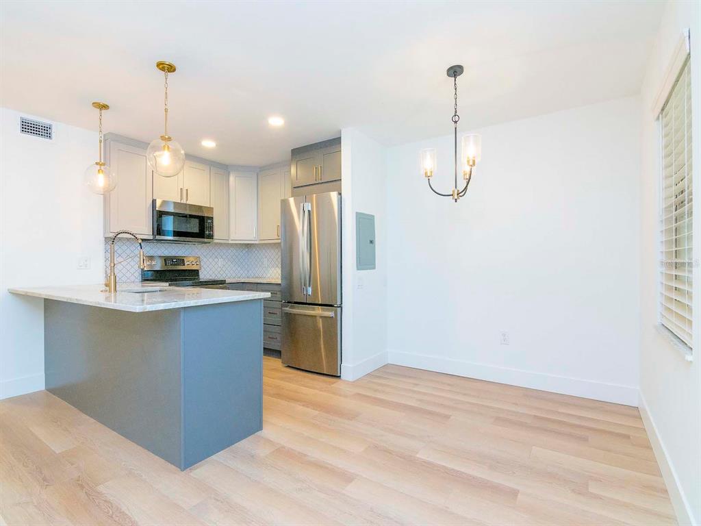 107 South Obrien Street, Unit 118 Tampa, FL 33609 - Photo 5 of 30 a kitchen with refrigerator and microwave