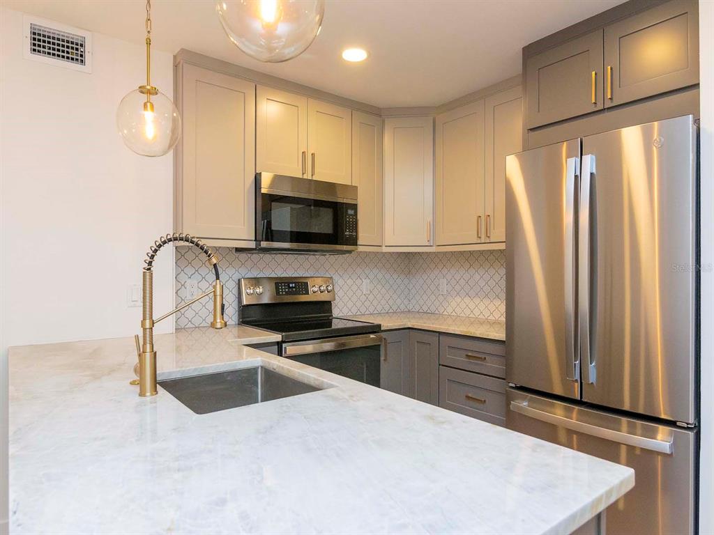 107 South Obrien Street, Unit 118 Tampa, FL 33609 - Photo 9 of 30 a kitchen with stainless steel appliances a stove sink and microwave