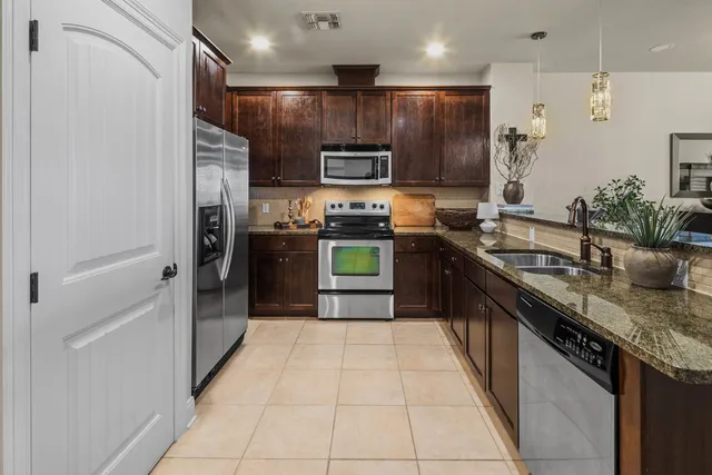 a kitchen with stainless steel appliances granite countertop a refrigerator and a sink