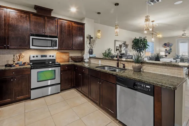 a kitchen with stainless steel appliances granite countertop a sink and stove top oven