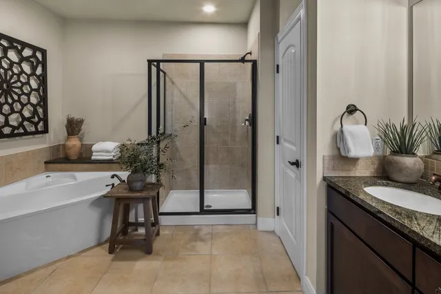 a spacious bathroom with a granite countertop sink a mirror and a bathtub