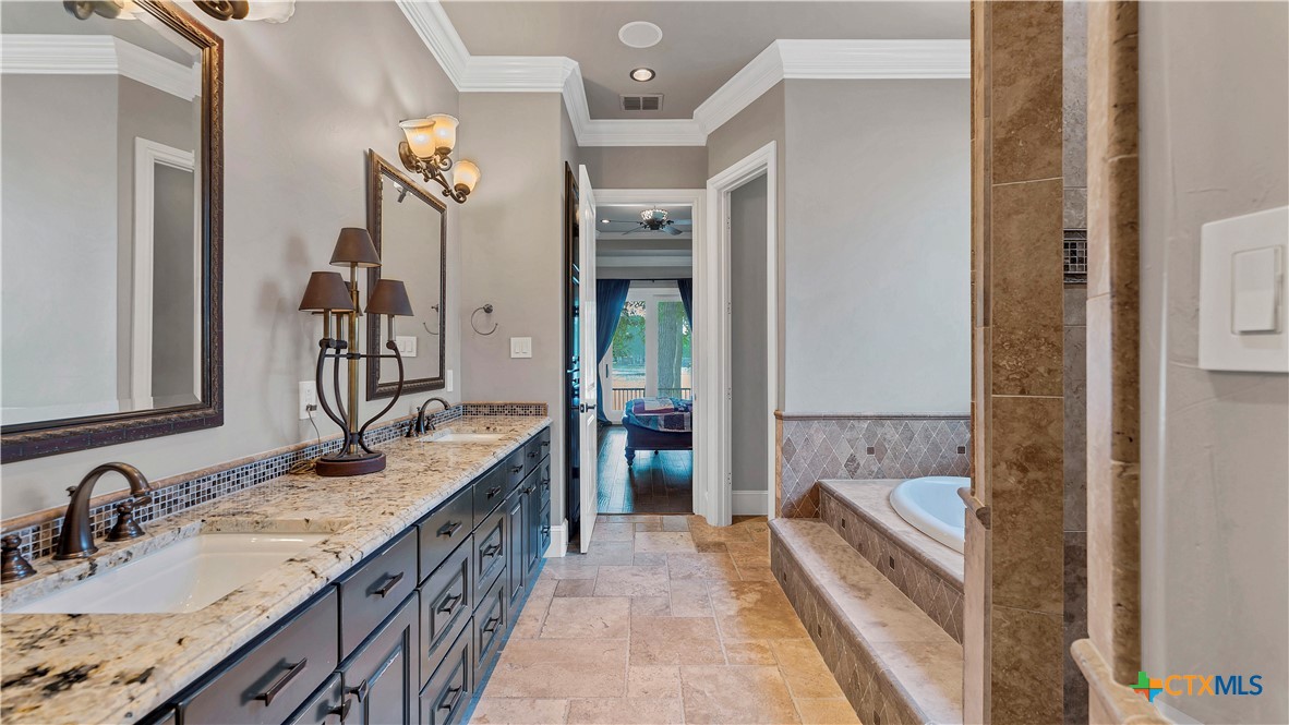 368 Rancho Road New Braunfels, TX 78130 - Photo 20 of 47 a bathroom with a granite countertop tub double vanity sink and a large mirror