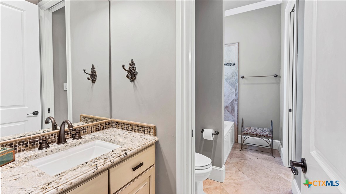 368 Rancho Road New Braunfels, TX 78130 - Photo 29 of 47 a bathroom with a granite countertop sink and a mirror