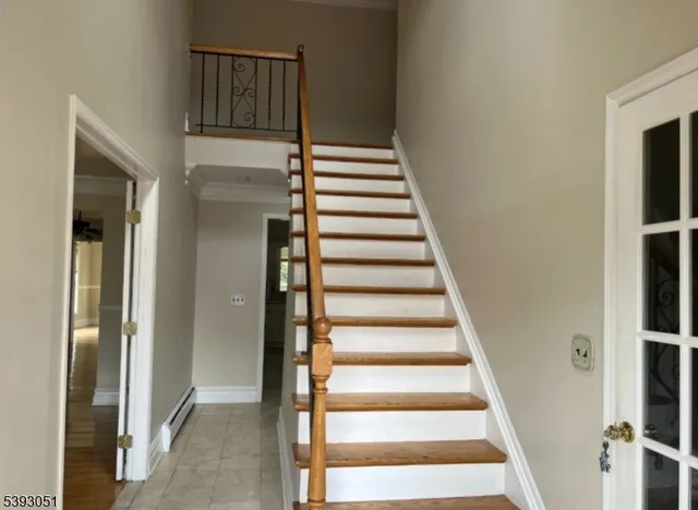 a view of staircase with wooden floor and white walls