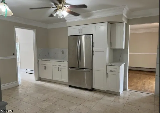 a kitchen with white cabinets and refrigerator