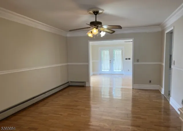 a view of an empty room with wooden floor
