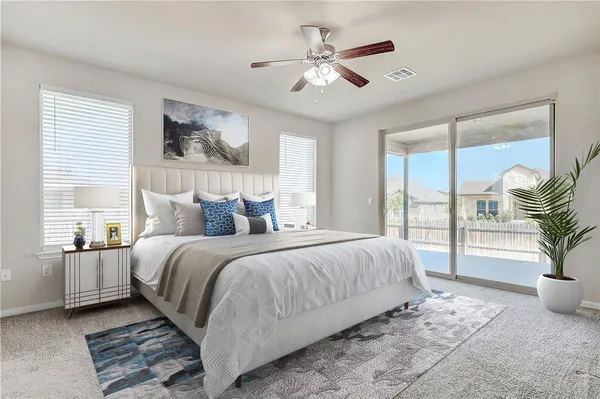 a spacious bedroom with a large bed and a chandelier fan