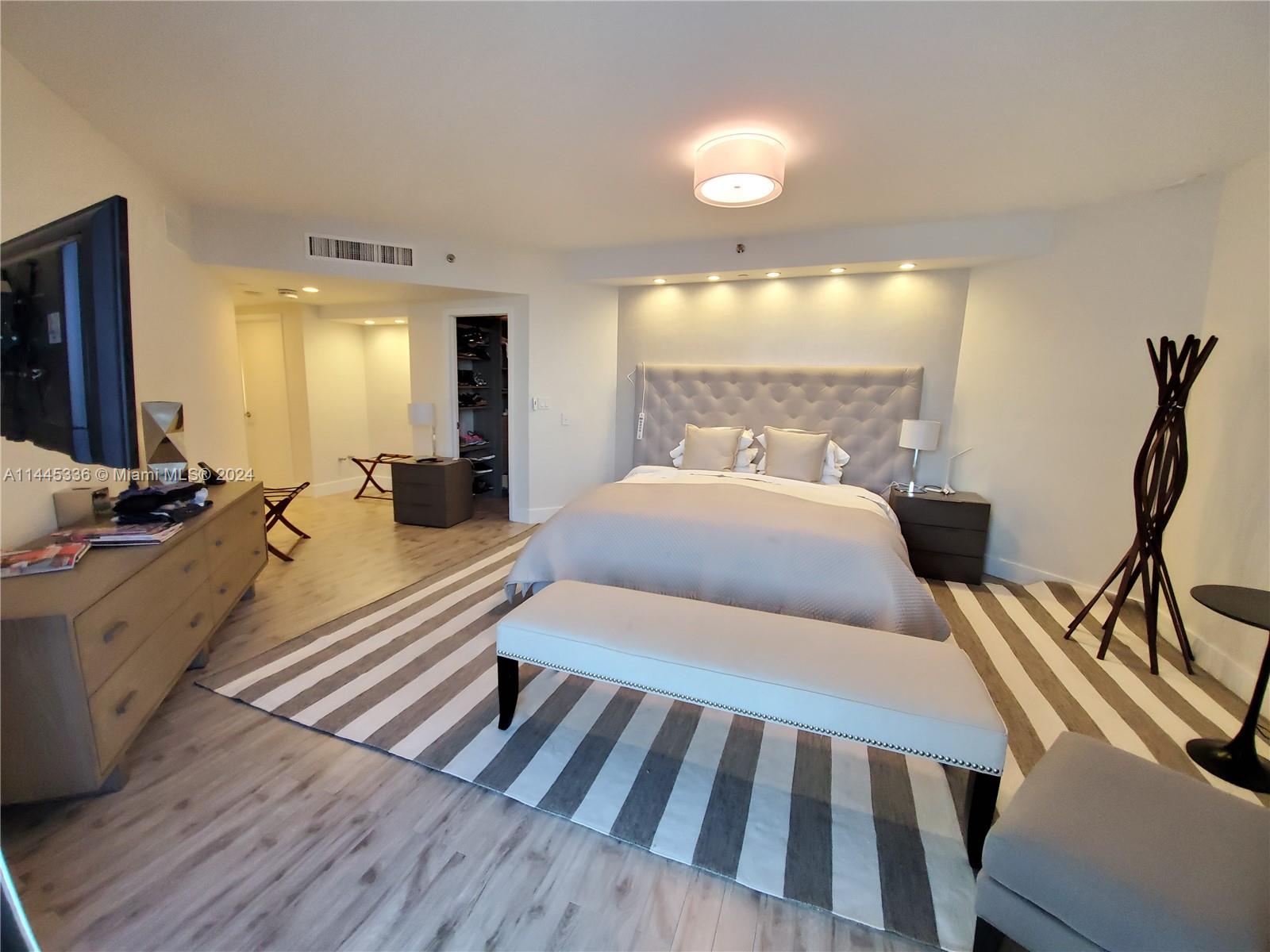 3000 Island Boulevard, Unit 2603 Aventura, FL 33160 - Photo 12 of 28 a bedroom with two beds and a large mirror next to a window