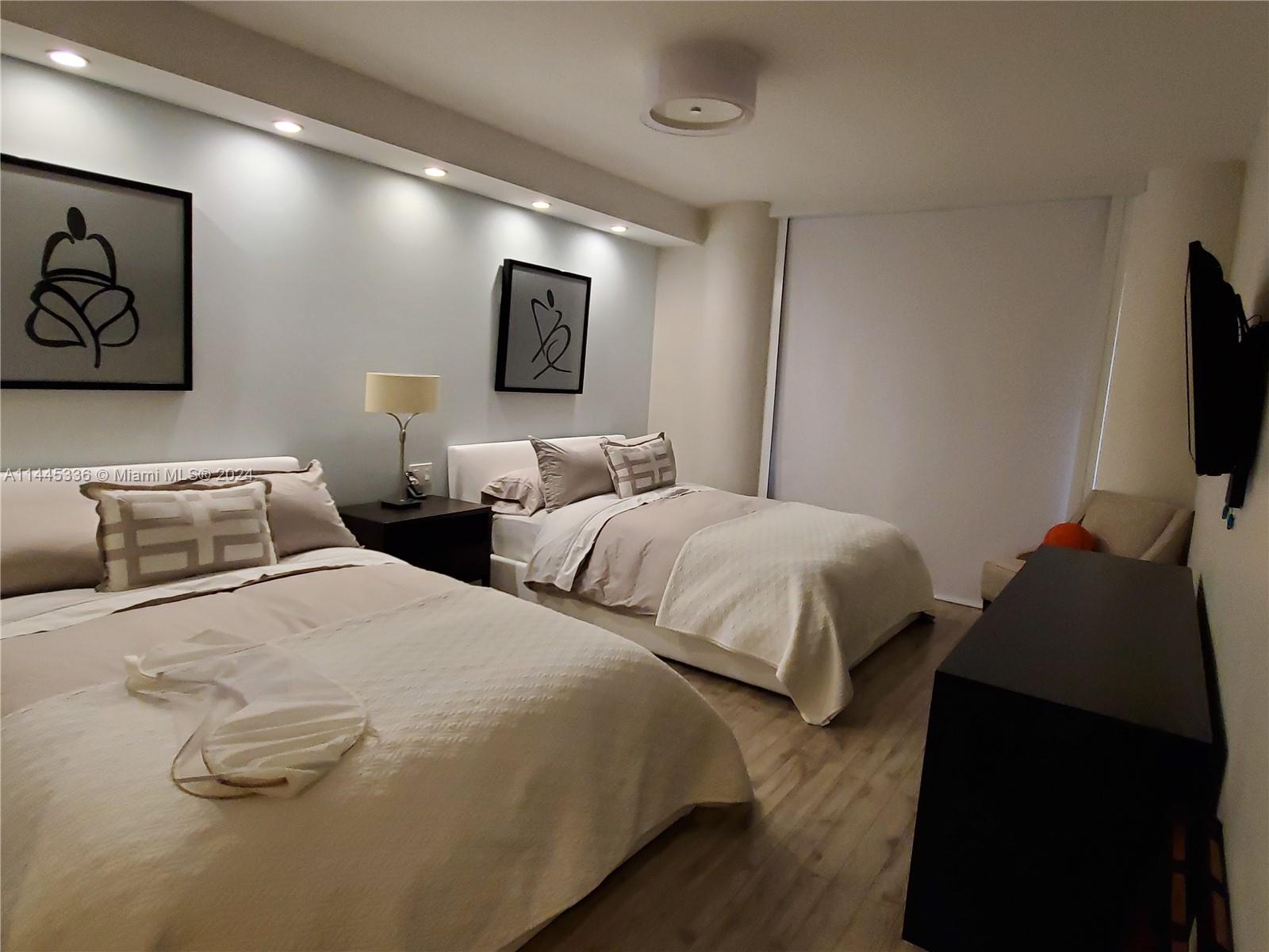 3000 Island Boulevard, Unit 2603 Aventura, FL 33160 - Photo 16 of 28 a bedroom with two beds and a flat screen tv