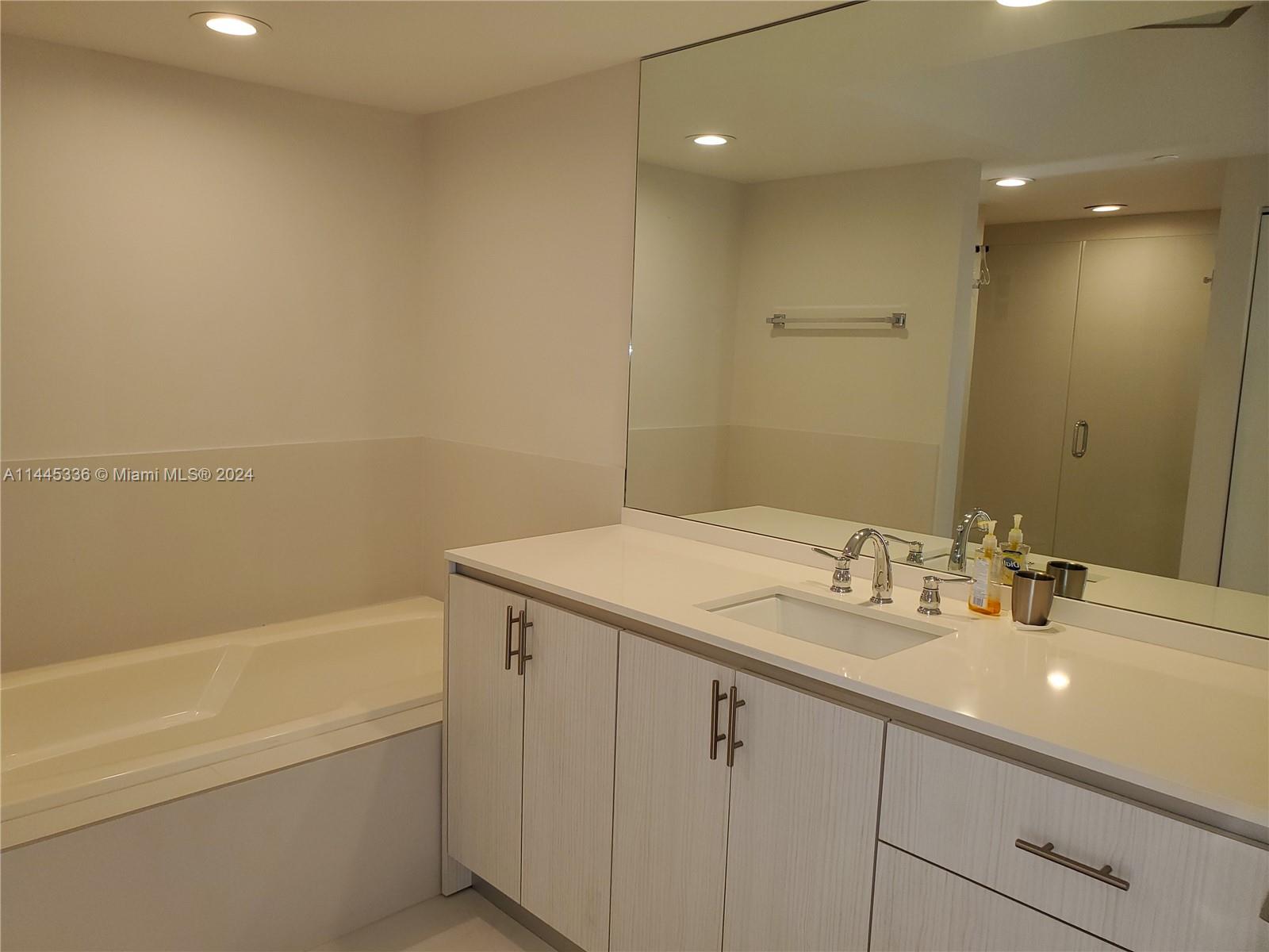 3000 Island Boulevard, Unit 2603 Aventura, FL 33160 - Photo 17 of 28 a bathroom with a granite countertop sink mirror and toilet